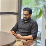 Front of freelance digital marketer's father Sitting on a chair and scrolling on his phone